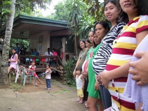 Pregnant women, all in a row, leading up to the birthing clinic.